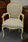 A French style upholstered open armchair with cream painted frame.