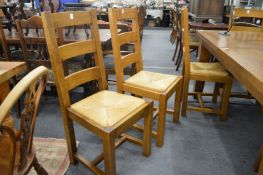 A set of eight oak and rush seated dining chairs.