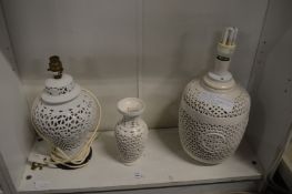 Two blanc de chine lamp bases and a similar vase, all with pierced decoration.