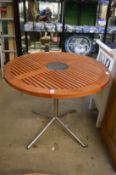 A teak and metal circular garden table.