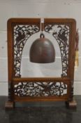 A Chinese 'dinner gong' or temple bell, the hardwood frame with pierced decoration.