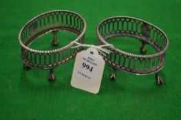 A pair of silver oval table salt frames.