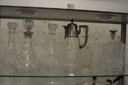 Cut glass decanter with silver collar, a claret jug with plated mounts and five other decanters.