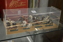A Die cast set of twelve mounted cavalry, in a perspex case.