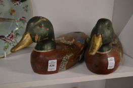 A pair of carved wood and painted models of ducks.