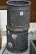A pair of cylindrical faux lead planters.