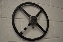 A novelty steering wheel with a Smiths clock at the centre (af).