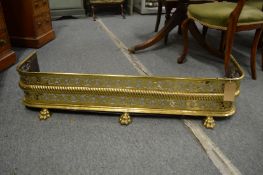 A 19th century brass fender with pierced fretwork front on brass claw feet, 3'7