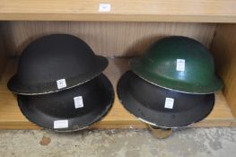 Four old WWII tin helmets.