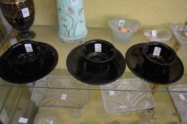 A set of three glass bowls and stands.