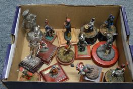 A collection of fourteen various metal soldiers, on a stand.