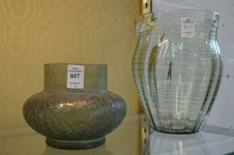 Two iridescent green glass vases.