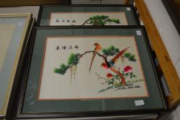 A pair of colourful Chinese embroidered pictures depicting exotic birds on branches.