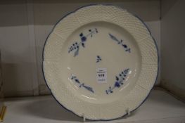 A Chantilly creamware plate with basket weave border painted with blue flowers.