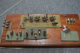 Large perspex case containing various sets of military figures on wooden bases.