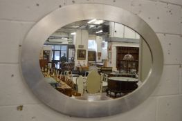 A silver framed oval wall mirror.