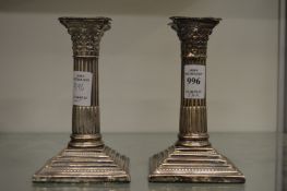 A pair of silver corinthian column candlesticks.