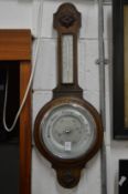 An oak cased aneroid barometer and thermometer.