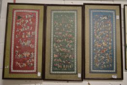 A set of three Chinese embroidered pictures depicting numerous figures.