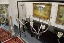 A pair of stylish chrome plated five branch chandeliers with crystal shades.