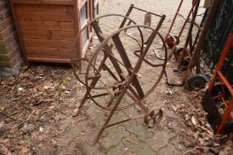 A wrought iron garden hose frame.