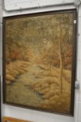 A large Oriental embroidered picture of a wooded river landscape.