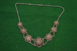 A filigree silver necklace.