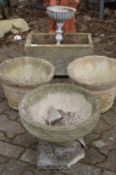 Four various composite garden planters and a small white painted planter.