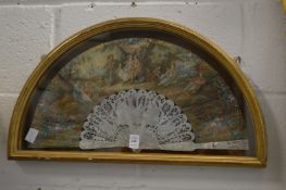 A gilt wood display case containing a decorative painted French fan.