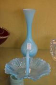 A blue opaque glass basket and similar vase.