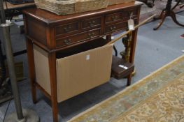 A mahogany two tier side table with six small drawers.