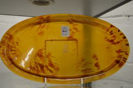 An oval dressing table tray possibly tortoiseshell, inset with a gold monogram and crown.