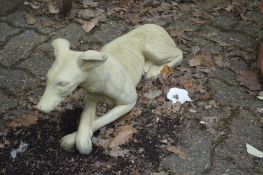 A pair of garden ornaments modelled as recumbent greyhounds.