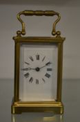 A brass carriage clock with replacement escapement (original escapement included).