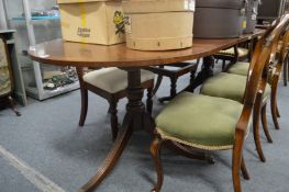 A mahogany twin pedestal dining table with one leaf.