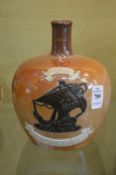 A Doulton salt glazed jug with moulded decoration 'Special Highland Whisky'.