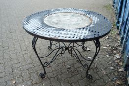 A wrought iron and composite circular garden table.