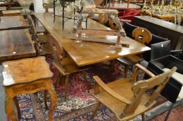 An unusual Swiss walnut refectory style drawer leaf dining table together with a set of ten dining