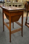 An Edwardian mahogany work table with bi-fold top.