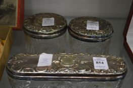 A cut glass three piece dressing table set with plated mounts.
