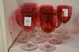 A quantity of cranberry coloured wine glasses.