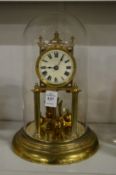 A brass anniversary clock with glass dome.