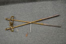 A pair of brass and steel pokers with lion handles.