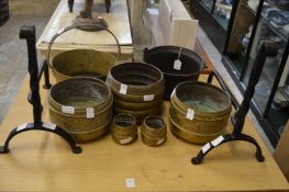 A pair of wrought iron fire dogs, various brass jardinieres, preserve pan etc.