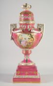 A SEVRES TWO HANDLED PORCELAIN URN AND COVER on a stand with rose pompadour ground edged in gilt.