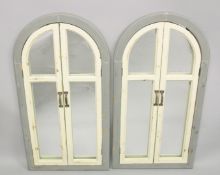 A PAIR OF GREY AND WHITE PAINTED ARCH SHAPED SHUTTER STYLE MIRRORS. 3ft 4ins x 1ft 9ins.