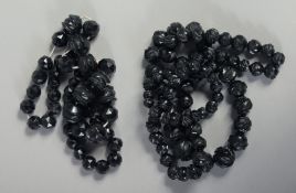 TWO VICTORIAN CARVED JET NECKLACES. 34ins & 24ins long, 180gms.