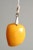 A SMALL RUSSIAN BUTTER SCOTCH AMBER PENDANT with a Russian silver ring. 4.2gms.
