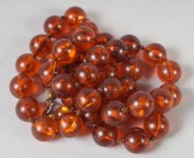 AN AMBER GRADUATED BEAD NECKLACE, 22ns long, 40 beads. 37gms.