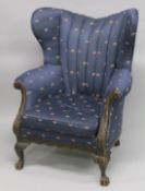 A GEORGE III STYLE MAHOGANY WING ARMCHAIR on claw and ball feet.